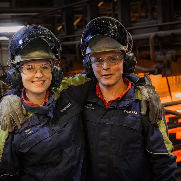 Two steel workers posing for a photo in production site