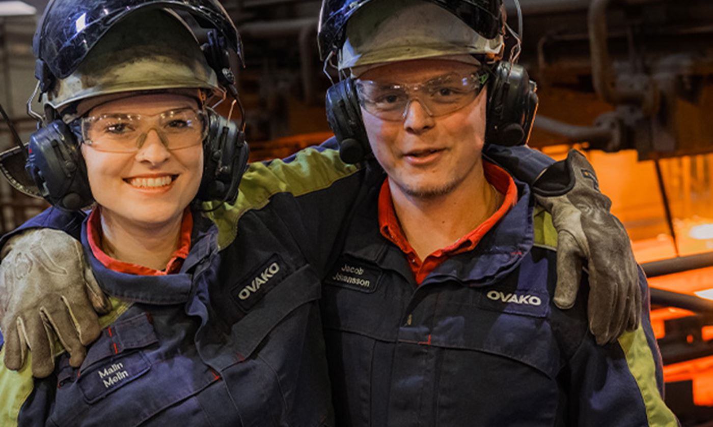 Two steel workers posing for a photo in production site