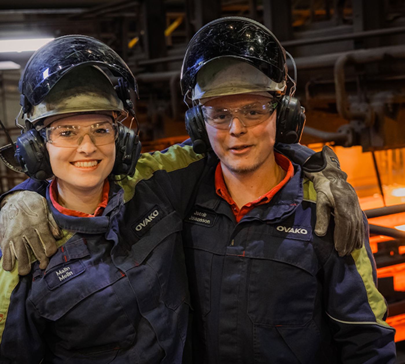 Two steel workers posing for a photo in production site